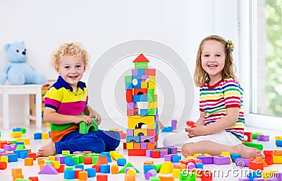 Kids playing with colorful toy blocks Stock Photo