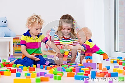 Kids playing with colorful toy blocks Stock Photo