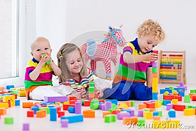 Kids playing with colorful toy blocks Stock Photo