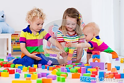 Kids playing with colorful toy blocks Stock Photo