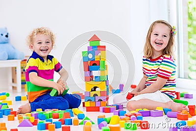 Kids playing with colorful toy blocks Stock Photo