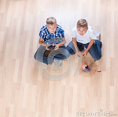 Kids playing with flying helicopter model at home using remote control Stock Photo