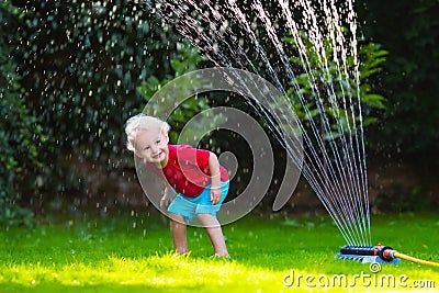 Kids playing with garden sprinkler Stock Photo