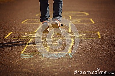 Kids playing hopscotch on playground outdoors. Hopscotch popular street game. Stock Photo