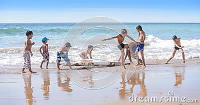 Kids playing with old surfboard, Taghazout surf village, agadir, morocco Editorial Stock Photo