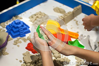 Kids playing plastic mold toys with sand on sandbox. Stock Photo