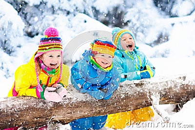 Kids playing in snow. Children play outdoors in winter snowfall. Stock Photo