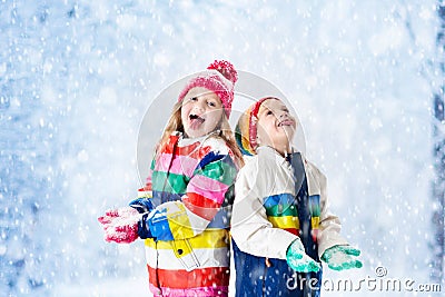 Kids playing in snow. Children play outdoors in winter snowfall. Stock Photo