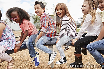 Kids playing on a spinning carousel in their schoolyard Stock Photo