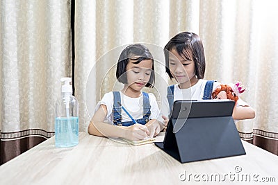 Kids playing and stay at home, children funny and joyful learn online in tablet on table, Stock Photo