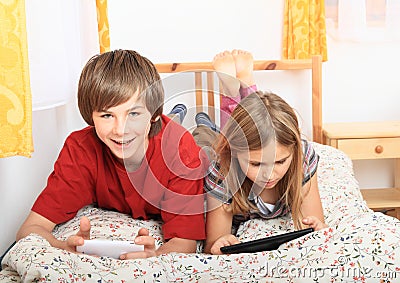 Kids playing with tablet and smartphone Stock Photo