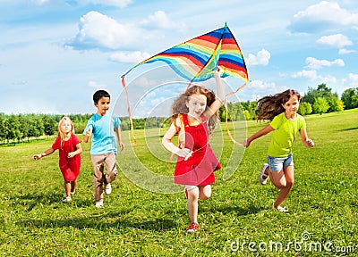 Kids run with kite Stock Photo