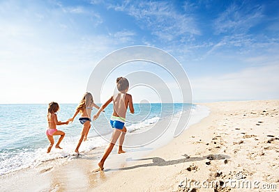 Kids running along beach during summer vacation Stock Photo