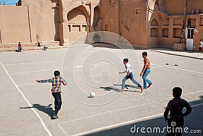 Kids running on football playground on Middle Eastern street Editorial Stock Photo