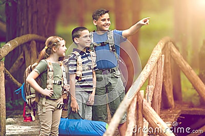 Kids scouts traveler with backpack hiking on bridge Stock Photo