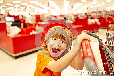 Kids shopping. Joyful beautiful child boy in supermarket buys vegetables. Healthy food for children. Cute kid with smile Stock Photo