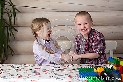 Kids siblings brother and sister playing constructor, share toys Stock Photo