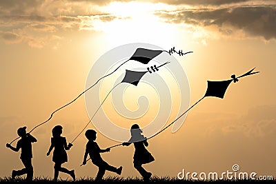 Kids silhouettes playing with kites Stock Photo