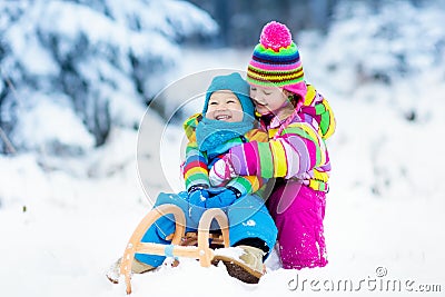 Kids on sleigh ride. Children sledding. Winter snow fun. Stock Photo