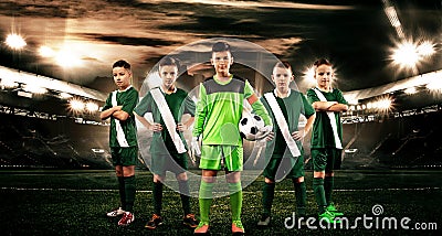 Kids - soccer champions. Boys in football sportswear on stadium with ball. Sport concept with soccer team. Stock Photo