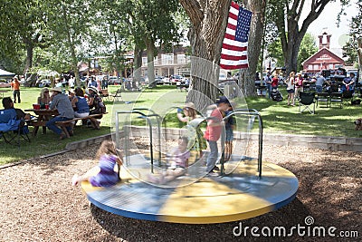 Kids spin on playground in Town Park Editorial Stock Photo