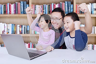Kids and teacher raise hands in library Stock Photo