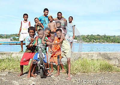 Kids and teens posing on bank of sea in Manokwari Editorial Stock Photo