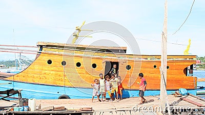 Kids and teens posing in front of traditional papuan ship Editorial Stock Photo