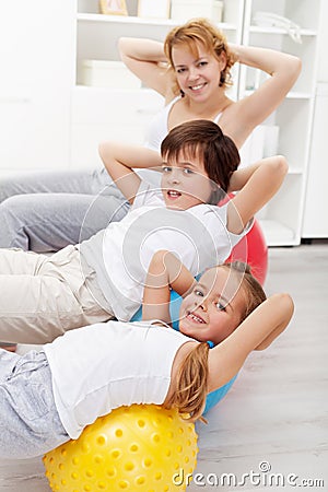 Kids with their mother doing gymnastic exercises Stock Photo