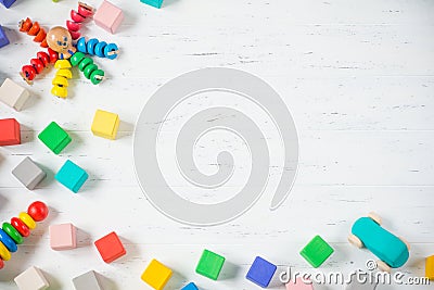 Kids toys frame wooden blocks, octopus, car, pyramidion on white wooden background. Flat lay. Copy space for text. Stock Photo