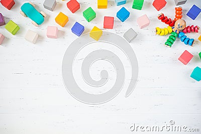 Kids toys frame wooden blocks, octopus, car on white wooden background. Flat lay. Copy space for text. Stock Photo
