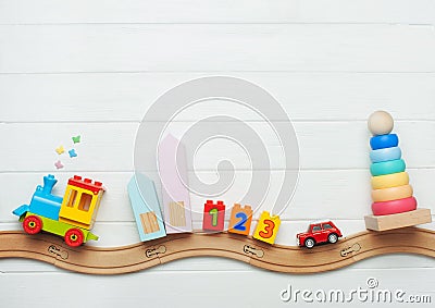 Kids toys on toy wooden railway on white wooden background Stock Photo