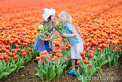 Kids in tulip flower field. Windmill in Holland Stock Photo