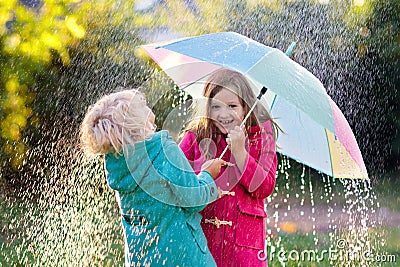 Kids with umbrella playing in autumn shower rain Stock Photo