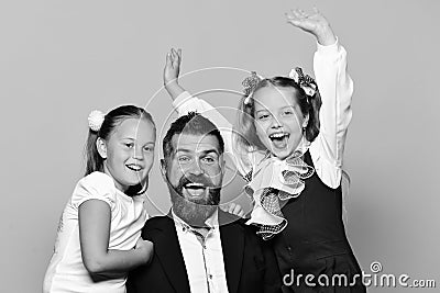 Kids wearing school clothes and bows near bearded teacher Stock Photo
