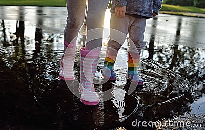 Kids wearing wellingtons in the puddle Stock Photo