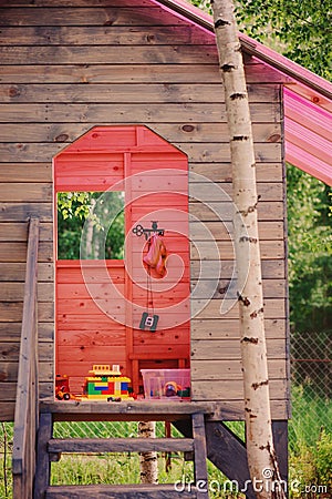 Kids wooden tree house with pink roof in summer forest Stock Photo