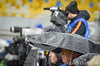 KIEV, UKRAINE - December 12, 2018: Journalists photographers are protected from snow during the UEFA Champions League match Editorial Stock Photo