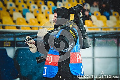 KIEV, UKRAINE - December 12, 2018: Photographer and journalist working with the camera during the UEFA Champions League match Editorial Stock Photo