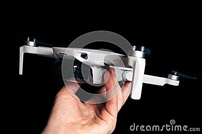 Dji Mavic Mini 2 drone in hand close-up on black Editorial Stock Photo