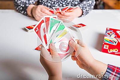 Kiev, Ukraine - Jeniaury 31th 2020 : Uno cards in hand little child boy; American card game Editorial Stock Photo