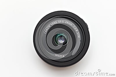 Kiev, Ukraine - March 05th, 2021: Kiev, Ukraine - March 05th, 2021: Pancake lens Canon EF-S 24 mm STM, front glass up. Top view on Editorial Stock Photo