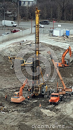 Workers repair equipment on the construction of the zero cycle foundation of the entertainment center Editorial Stock Photo