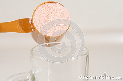 Kiev, Ukraine - May 31, 2020: A full measuring cup of pink protein powder from optimum nutrition with strawberry flavor Editorial Stock Photo