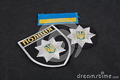 KIEV, UKRAINE - NOVEMBER 22, 2016. Patch and badge of the National Police of Ukraine on black uniform background Editorial Stock Photo
