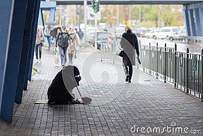 Kiev, Ukraine - October 24, 2018: Beggarly old woman sits on the sidewalk surrounded Editorial Stock Photo