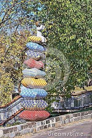  Statuette of a little fairy-tale character sitting on a stack of pillows. Editorial Stock Photo