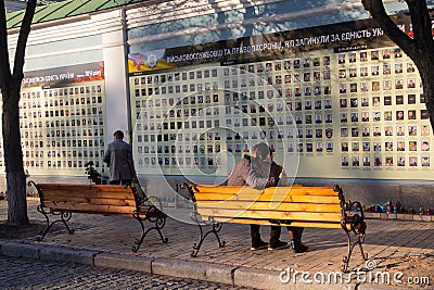 Kiev, Ukraine - October 14, 2018: Young couple is sitting on a bench near the alley in memory of the soldiers Editorial Stock Photo