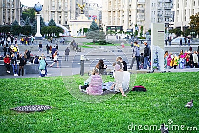 Kiev Ukraine - 09.22.2019: People relaxing on the grass in Maydan Nezalezhnosti Square in autumn at weekend in downtown Editorial Stock Photo