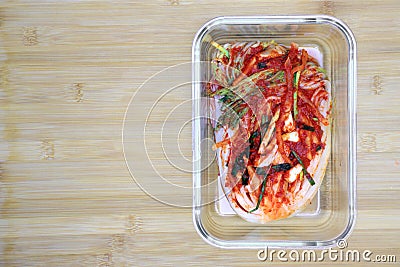 Kimchi cabbage in a glass rectangular bowl on wooden background, top view, Korean food, Stock Photo